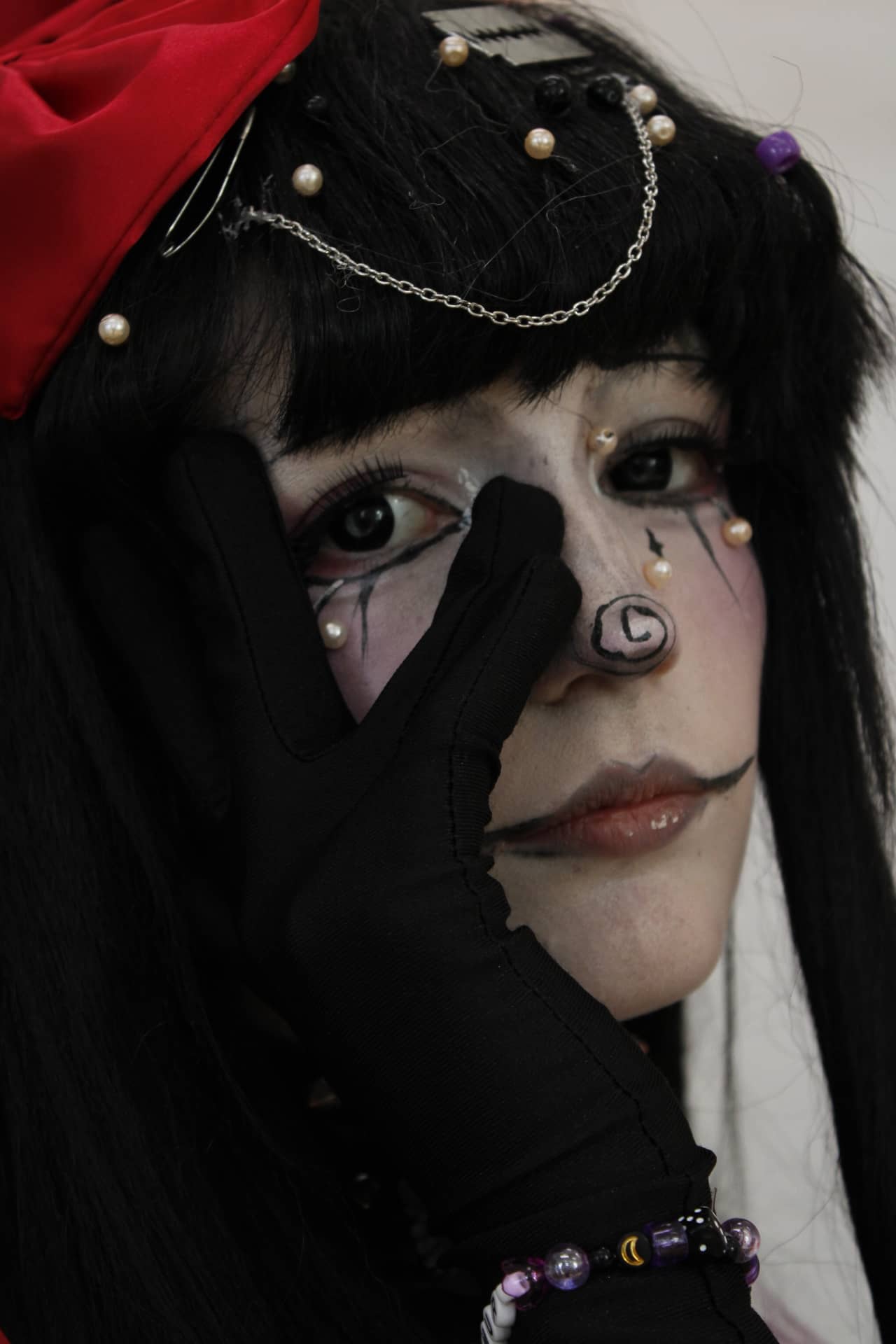 Make-up-Game on point: Perlen, schwarze Haare und rote Schleife